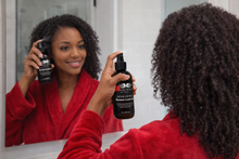 Load image into Gallery viewer, Black woman applying leave-in conditioner to healthy hair